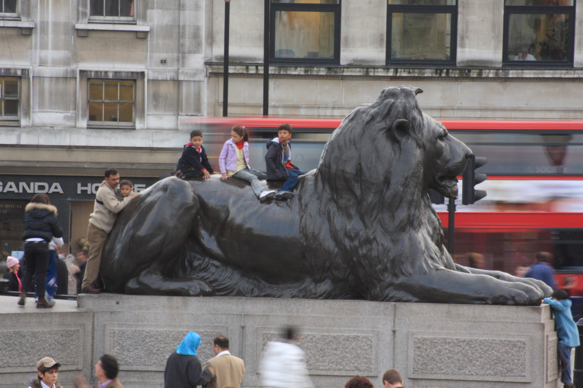 kids on one of the Lions in Trafalgar Square